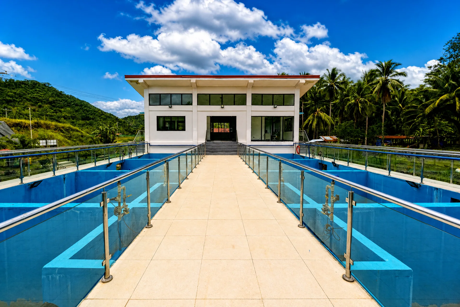 Blue filtration basins and central walkway leading to the treatment building