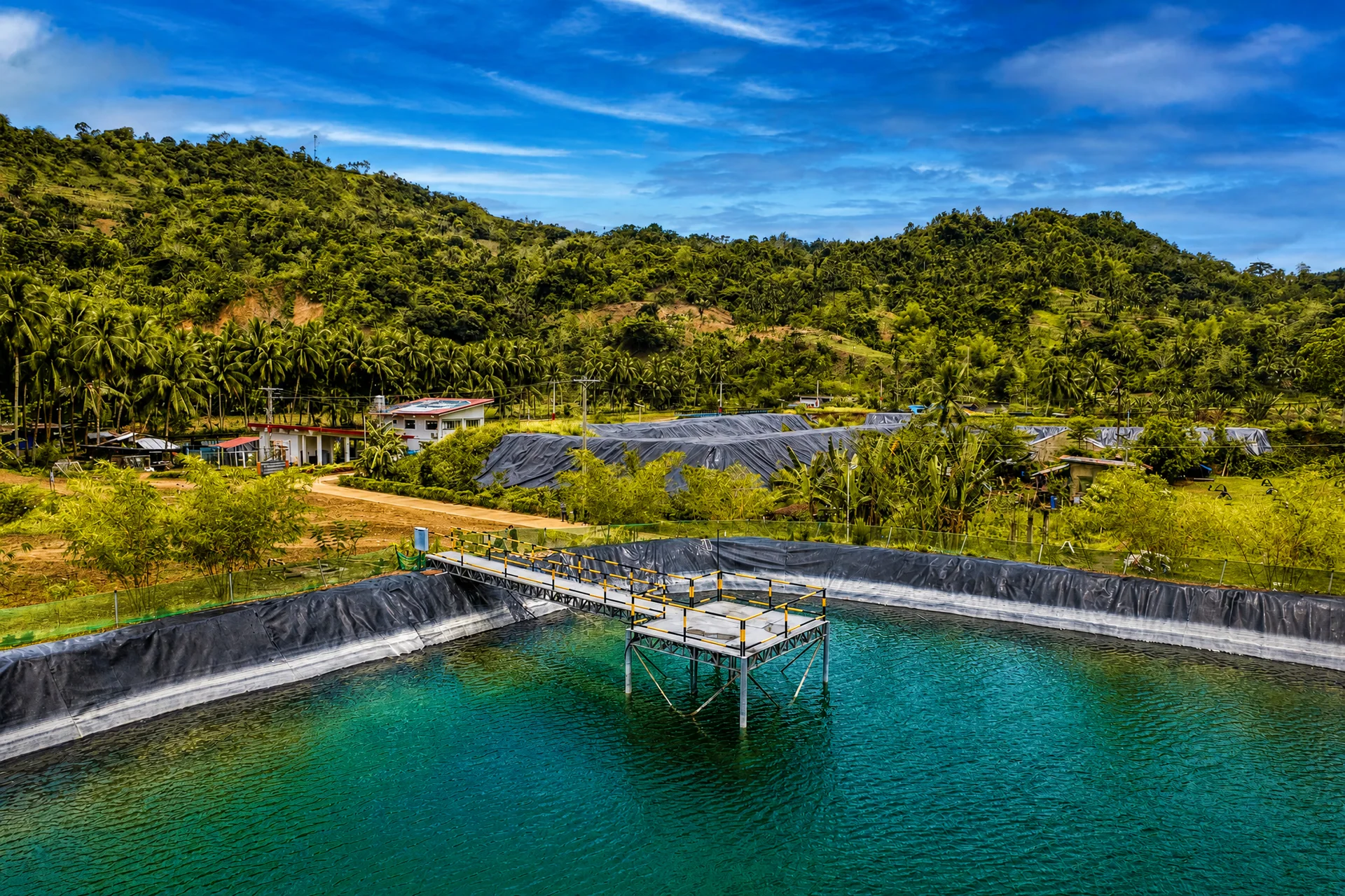 Reservoir with aeration equipment and a green hillside beyond
