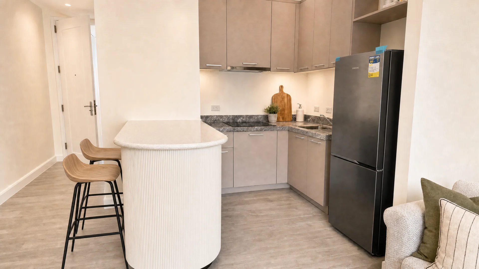 Curved kitchen counter with pale wood cabinets