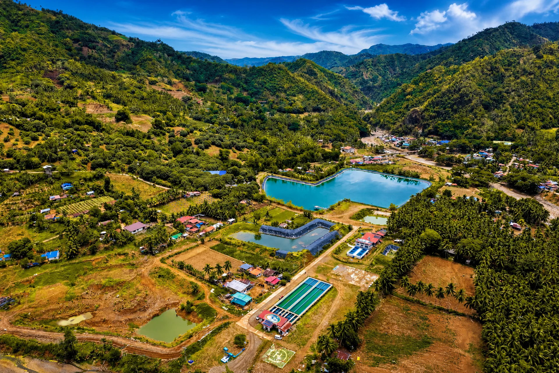 Aerial view of the Lusaran water treatment site and reservoir within the surrounding green hills