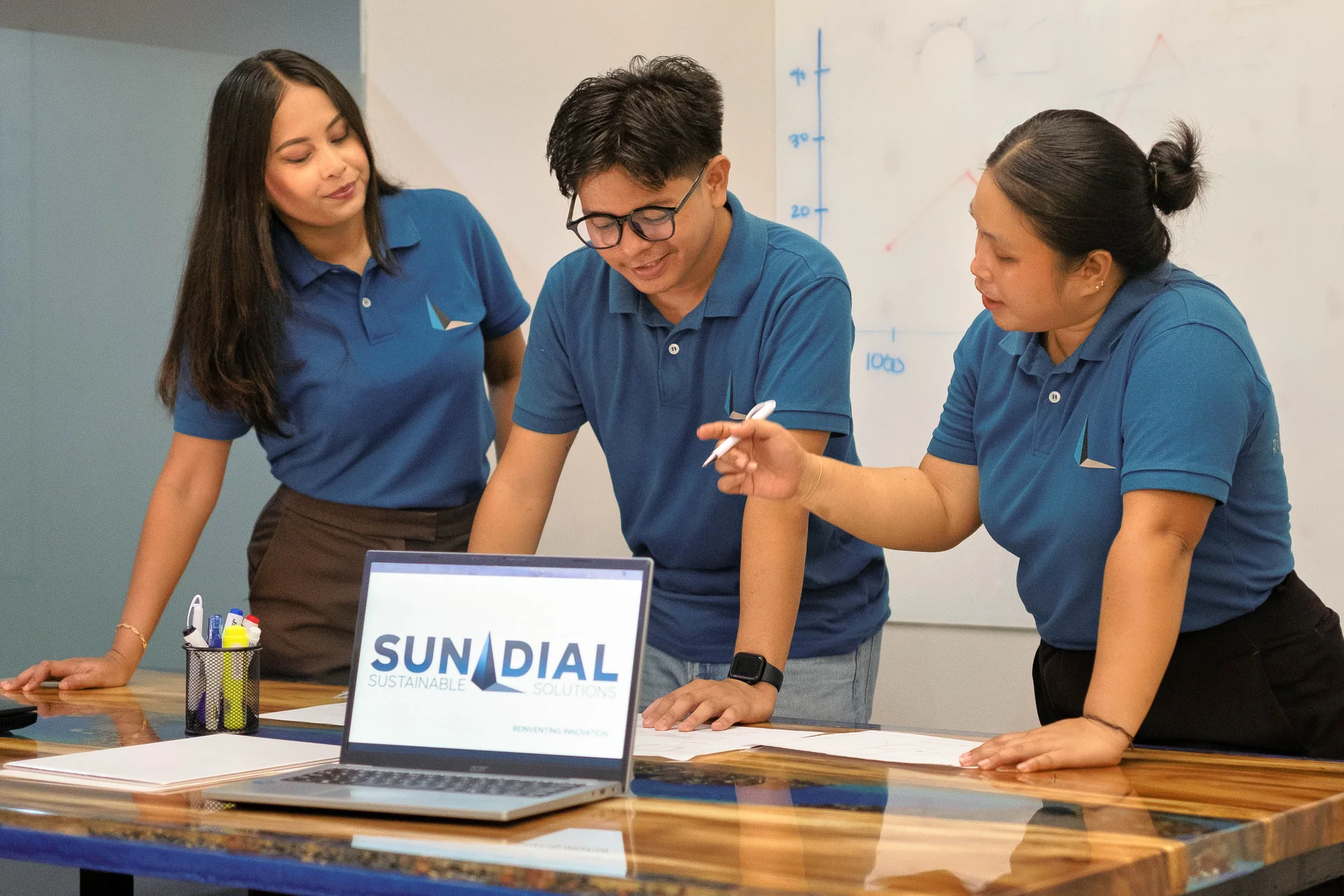 Sundial colleagues reviewing plans around the hand-cast river table