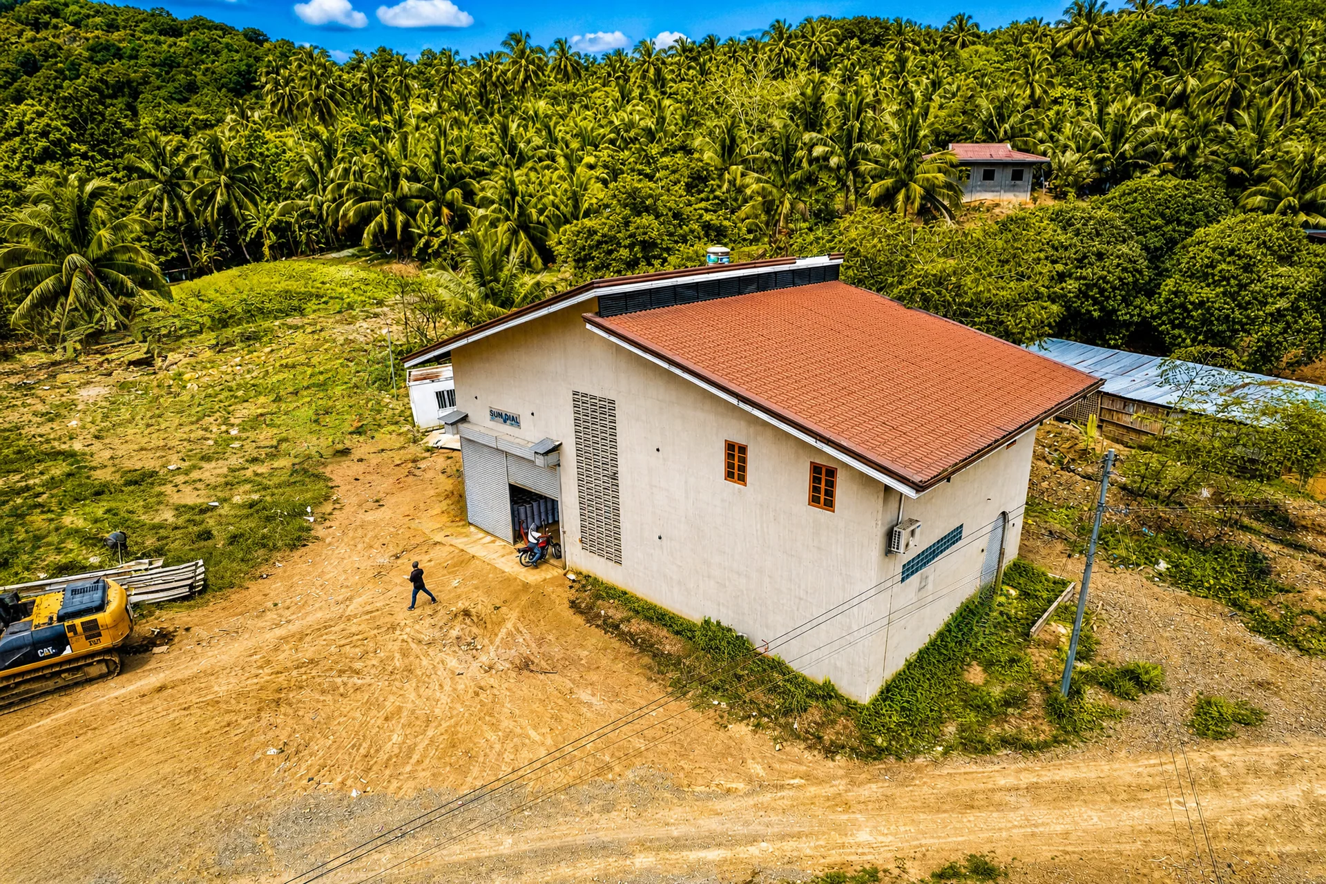 Concrete warehouse with a red roof at the Lusaran site
