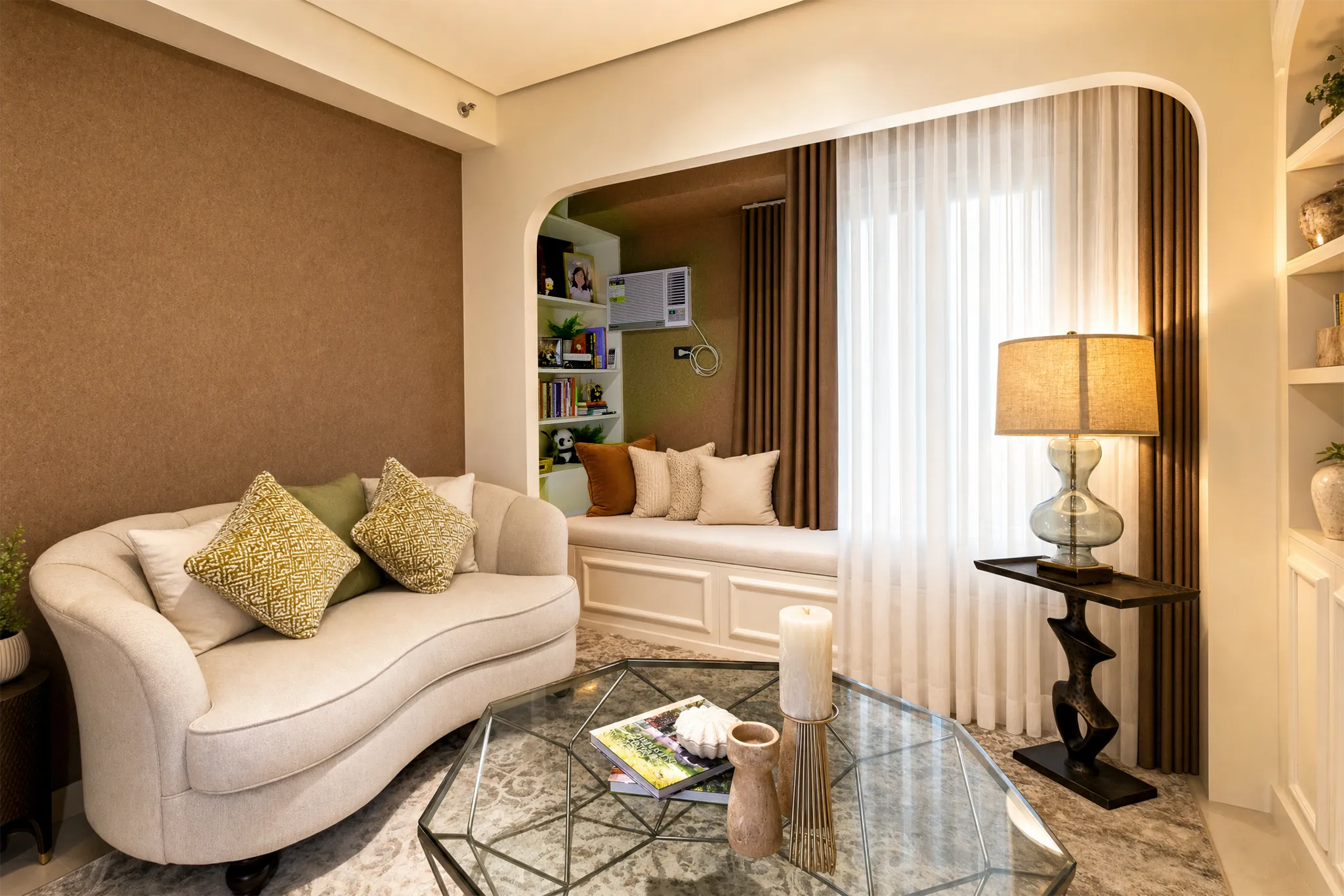 Solinea living room with a curved sofa, glass table, and soft window light